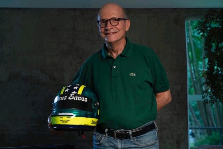 Alex Ribeiro swój chrześcijański slogan prezentował także na kaskach. Mężczyzna w jeansach i butelkowozielonej koszuli trzyma zielony kask z napisem "Jesus Saves". Na twarzy ma duże, czarne okulary.