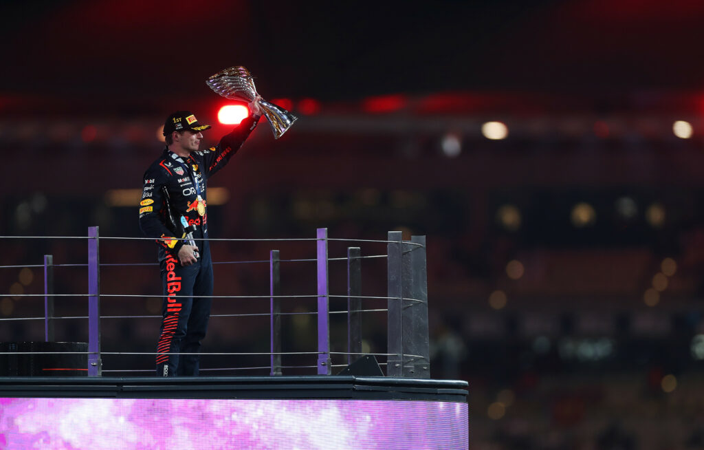 Max Verstappen stojący ze wszystkimi kierowcami na swoim poziomie w sezonie 2023 na podium Grand Prix Abu Zabi.
