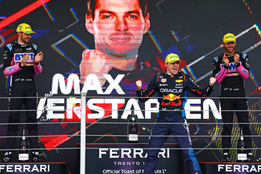 Max Verstappen oklaskiwany przez Estebana Ocona i Pierre'a Gasliego na podium po Grand Prix Brazyli 2024. 