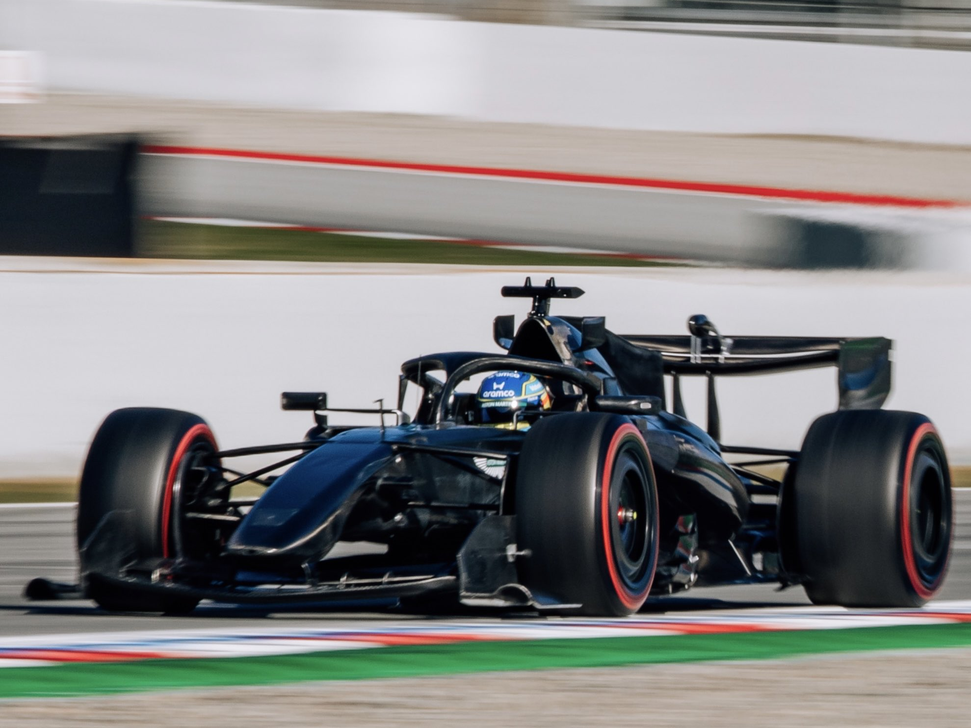 Fernando Alonso w, kamuflującym, czarnym Astonie Martinie w trakcie shakedownu.

